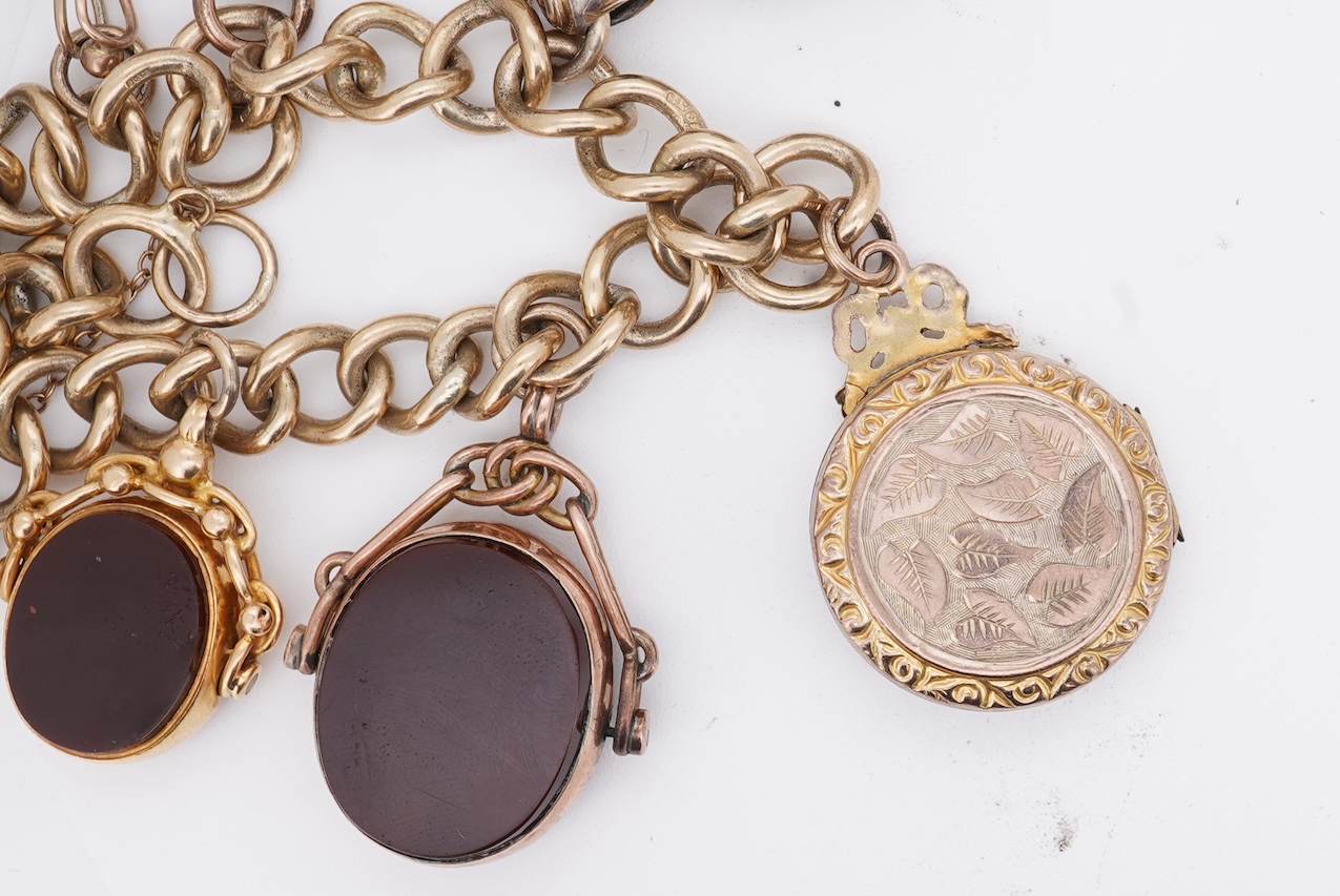 A 1970's 9ct gold curb link charm bracelet, with 9ct gold heart shaped clasp, hung with seven assorted gold or gilt metal mounted charms including six chalcedony set fob seals, gross weight 73 grams.